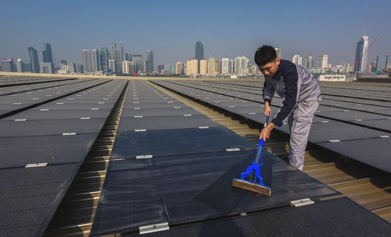 Un empleado mantiene limpias las instalaciones de una granja solar en China.